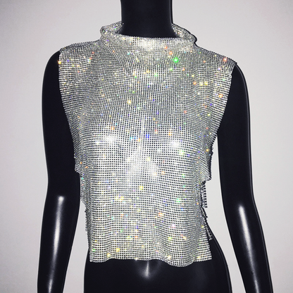 A woman wearing a sleeveless chain mail crop top with a high neck and rhinestone embellishments.
